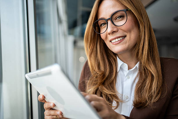 istock Businesswoman using digital tablet smiling at camera 2241192991
