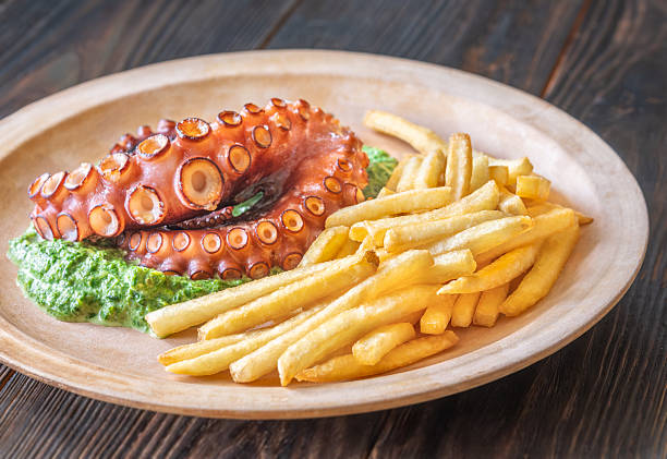 Roasted octopus tentacles served with creamy spinach and golden fries, rustic plating style