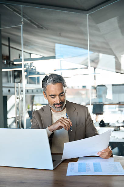 istock Middle aged professional business man manager checking documents in office. 2241204430