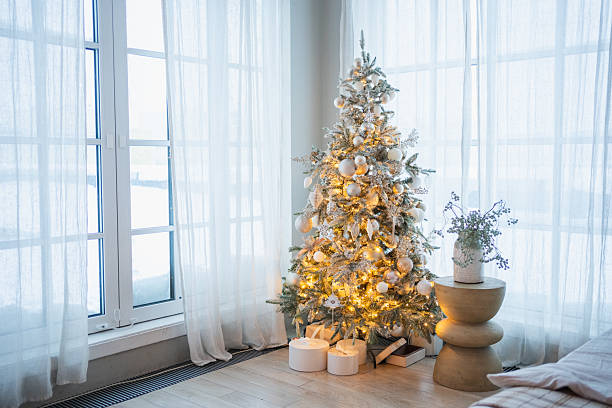 istock Classical Christmas decorated interior bedroom. Modern classic style interior design apartment with cozy king size bad and Christmas tree with white golden ornament decorations. Christmas eve at home. 2241204559