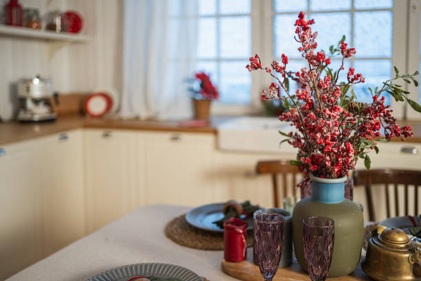 Classical Christmas decorated interior kitchen. Modern classic style interior design apartment dining with red frosty branches bouquet ornament Christmas decorations. Christmas eve at home