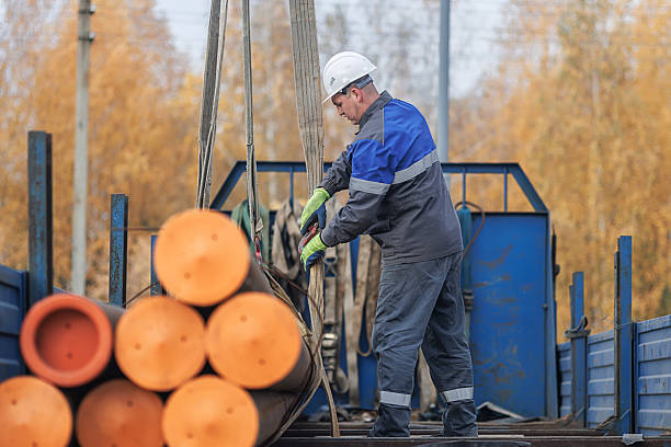 istock Worker Handling Steel Pipes at Construction Site 2241209591