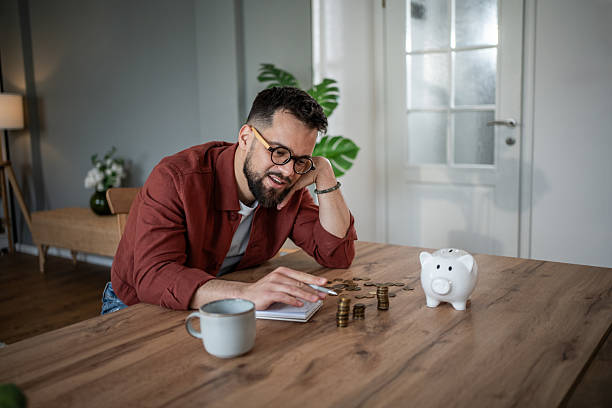 istock Man budgeting spending and saving money at home 2241209819