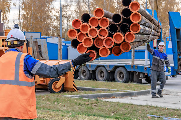 istock Construction Workers Handling Pipes at a Job Site 2241209870