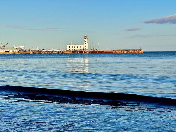 istock Scarborough lighthouse in North Yorkshire on a sunny evening casting a reflection on the sea 2241211309