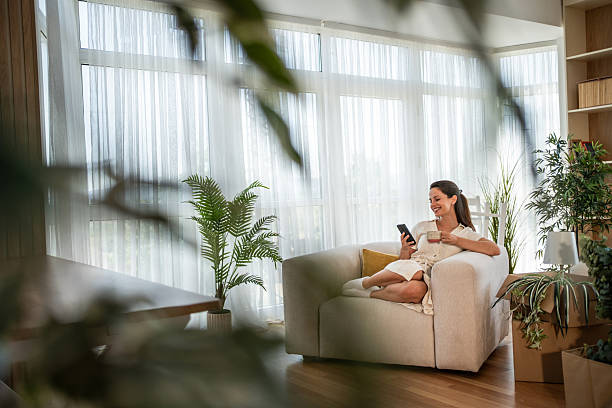 istock Woman relaxing at home checking smartphone 2241212384