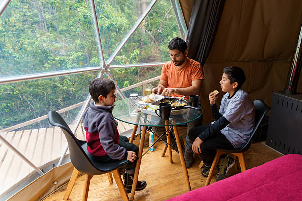 Family eating breakfast in glamping dome tent