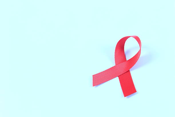 istock Aids awareness red ribbon on blue background 2241212552
