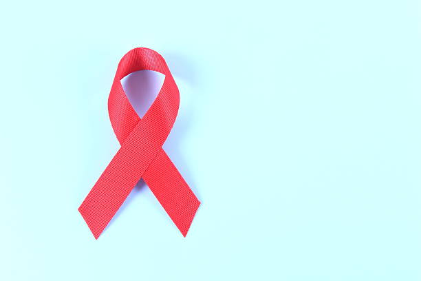 istock Aids awareness red ribbon on blue background 2241212643