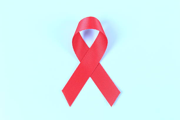 istock Aids awareness red ribbon on blue background 2241212667