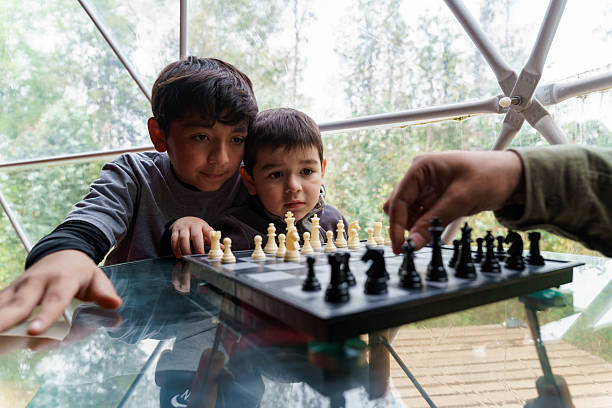 Family enjoying leisure time learning to play chess in a modern glamping dome