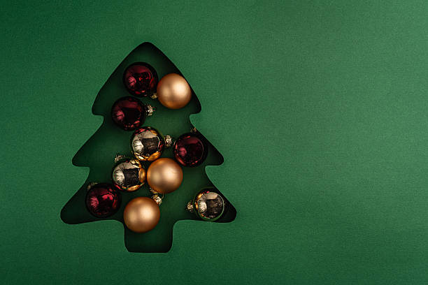 istock Gold Christmas Ornaments in Tree-Shaped Paper Cutout 2241214280