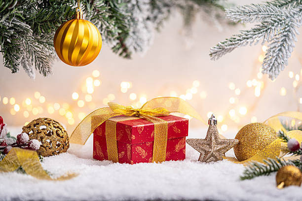 istock Red Gift Box with Gold Ribbon Among Christmas Decorations 2241214631