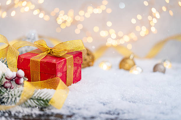 istock Red Christmas Gift Box with Gold Ribbon on Snowy Surface 2241214712