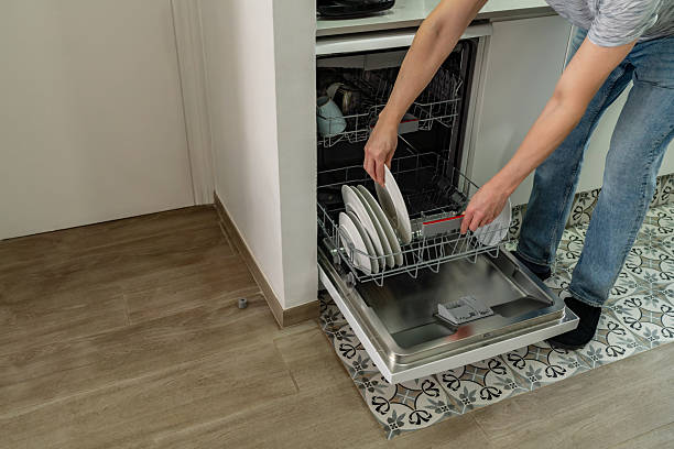 istock Man putting dishes in dishwasher 2241219529