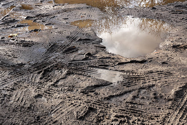 istock Muddy ground with tire tracks 2241226277