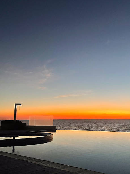 istock Infinity pool blending with ocean at golden sunset 2241228277