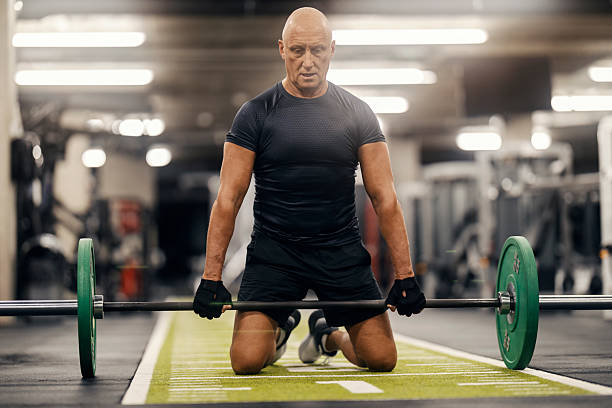 istock Senior man weightlifting, training in gym 2241230214