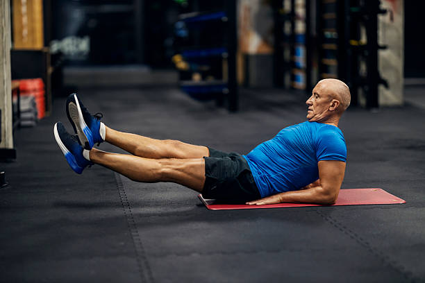 istock Senior man doing leg raise exercise in gym 2241230397