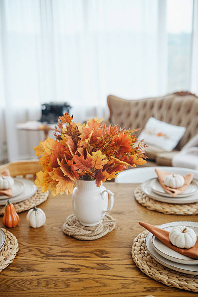 istock Autumn harvest table setting with maple leaves, pumpkins, and rustic decor. 2241230685