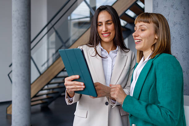 istock Businesswomen collaborating on digital tablet, discussing ideas in modern office environment 2241232298