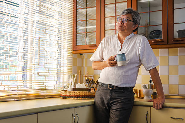 istock A content senior Chinese man sips his coffee and daydreams peacefully in the kitchen 2241232314