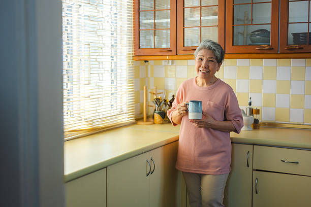 Senior Chinese woman savoring a cup of coffee at home
