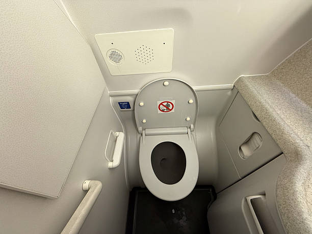 istock Airplane lavatory interior with toilet and flush button. Sanitation, hygiene, and compact design support passenger comfort and aviation travel convenience. 2241233417