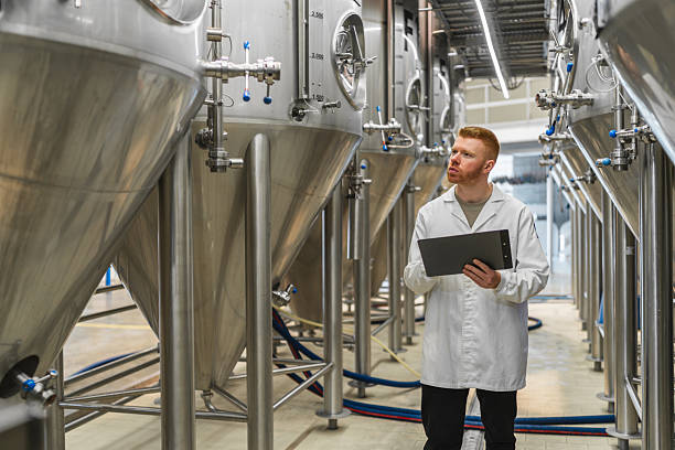 istock Brewing expert inspecting fermentation tanks in modern beer factory 2241233686