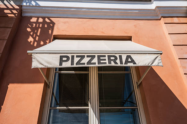 istock Restaurant pizzeria sign on orange wall building.. 2241235623