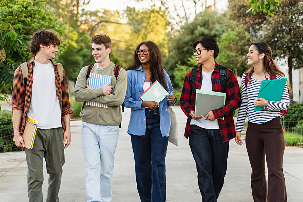 istock Group of university student friends walking going to classes. Diversity in school and education 2241235677