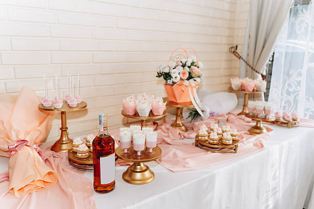 istock Elegant dessert table with cupcakes, sweets, and wine in a romantic pink and gold setting for a festive celebration 2241236109