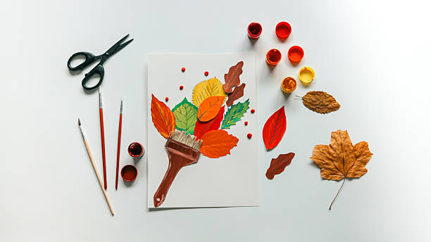 istock Autumn art composition with leaves, paint, and brushes on a white background. 2241239422