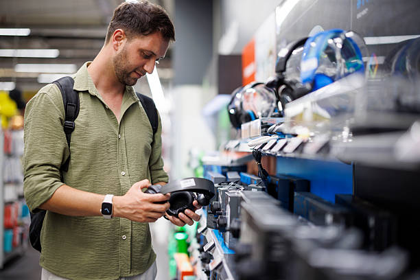 istock Man shopping for headphones in electronics store 2241239865