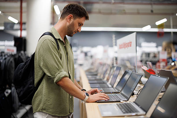 istock Modern male customer choosing laptop in retail computer store 2241239867
