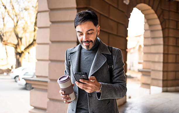 istock Urban man walking, drinking coffee, looking at phone 2241242868