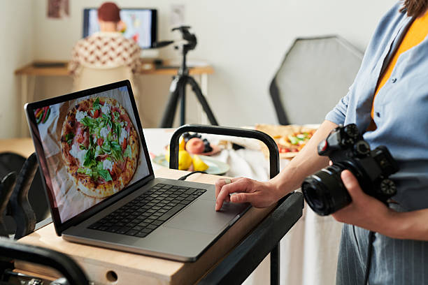 istock Woman Photographing Pizza with Laptop in Studio Setting 2241244961