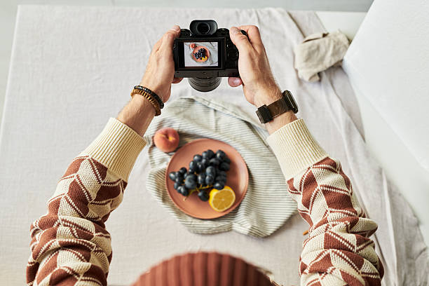 istock Man Photographing Fruit Plate with Digital Camera Overhead 2241245695