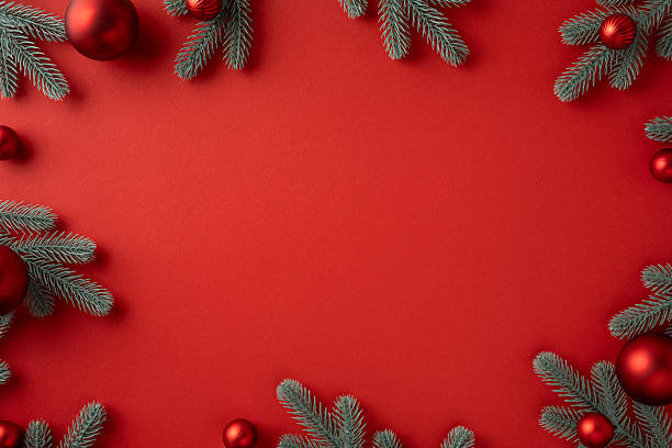 istock Layout with a vivid red backdrop framed by frosted pine branches and red ornaments, perfect for Christmas and New Year greetings 2241245907