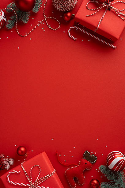istock Vertical red holiday scene with gift boxes, ribbons, baubles and a gingerbread reindeer, creating a warm festive mood for Christmas and New Year celebration 2241245908