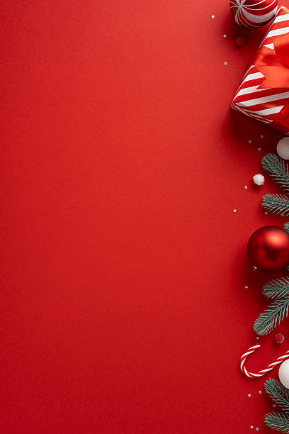 istock Vertical layout featuring a bold red background with wrapped gifts candy canes and pine branches creates a Christmas and New Year celebration mood suitable for greeting cards and holiday campaigns 2241245966