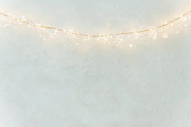 istock Warm String Lights on Textured Wall in Minimal Festive Interior 2241252222