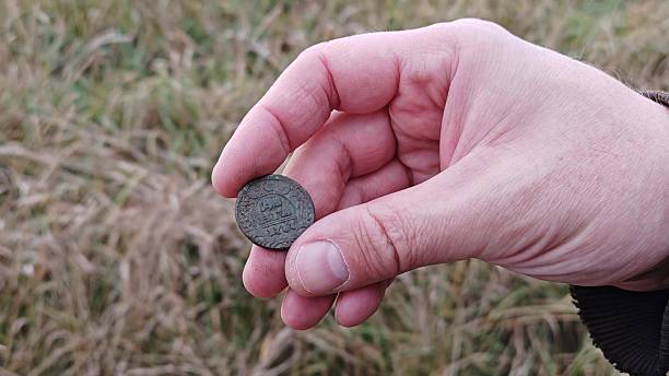 istock An ancient copper coin in the hands of a treasure hunter 2241253877