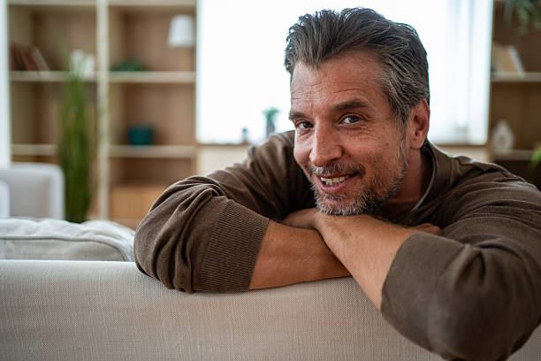 istock Man relaxing on sofa feeling happy at home 2241257010