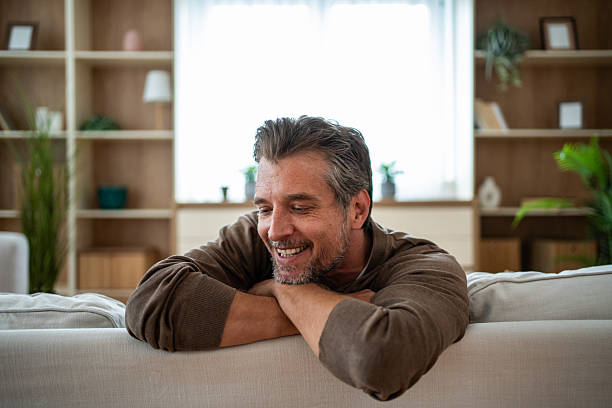 istock Smiling man relaxing at home feeling happy and content 2241257023
