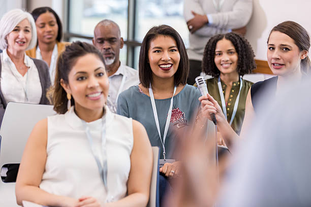 istock Diverse group of people engage in discussion with a microphone at a meeting or event. 2241257372