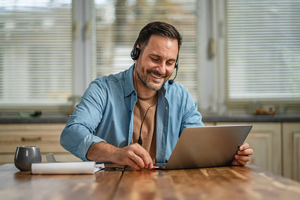 istock Man connecting headset to laptop for video conference 2241260957