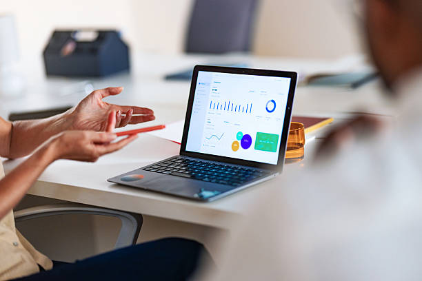 istock Business Meeting With Laptop Screen Displaying Analytics During Team Discussion In Modern Office 2241263694