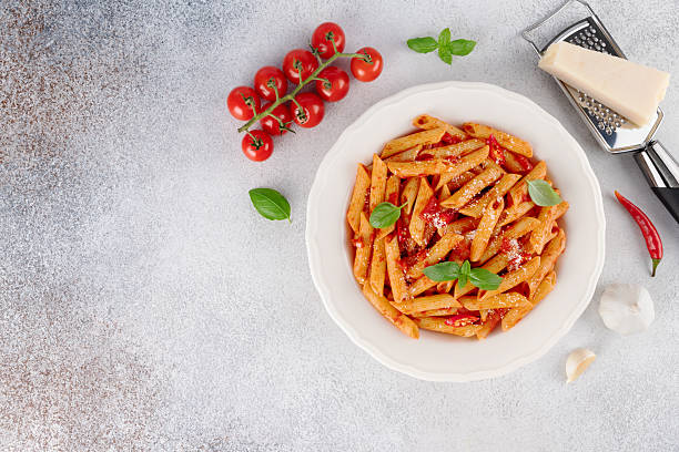 istock Arrabbiata pasta with tomato sauce, chili, parmesan basil on gray background. Top view. Copy space 2241264351