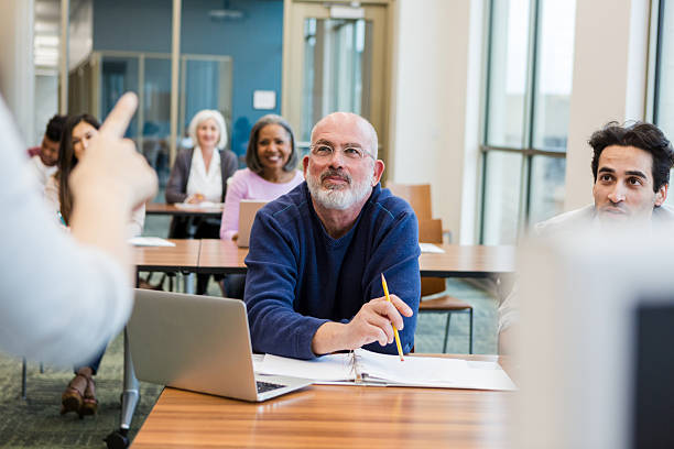 istock Diverse group of adults in a classroom setting attentively learning and engaging. 2241269720